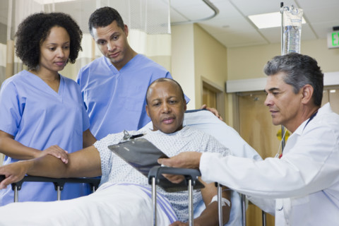 African man in hospital gurney looking at clipboard. Date : 2008