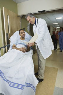 African man in hospital gurney reading paperwork. Date : 2008