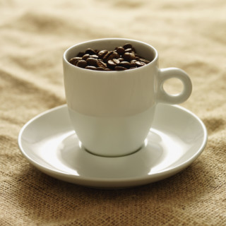 Mug filled with coffee beans. Date : 2008