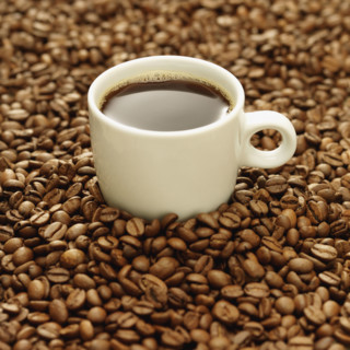 Cup of coffee surrounded by coffee beans. Date : 2008
