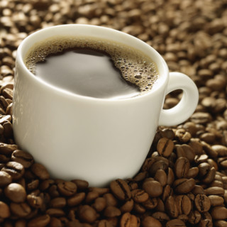 Cup of coffee surrounded by coffee beans. Date : 2008