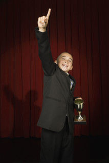 Boy holding trophy on stage. Date : 2008
