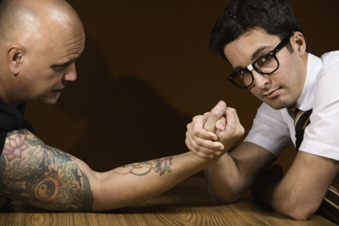 Nerdy man arm wrestling tattooed man. Date : 2008