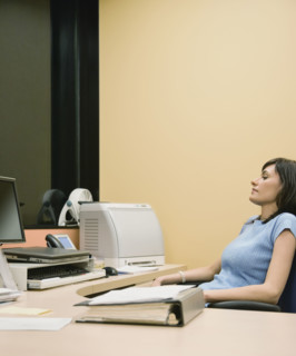 Businesswoman sitting at desk. Date : 2008