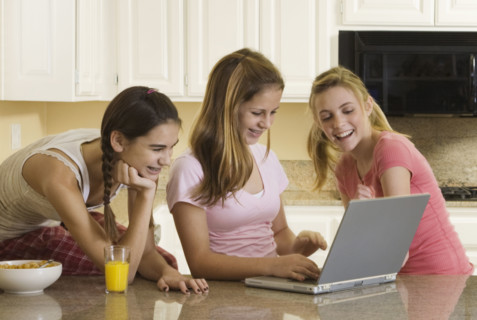 Teenaged girls looking at laptop. Date : 2008