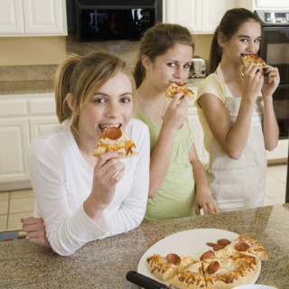 Teenaged girls eating pizza. Date : 2008