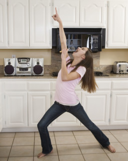 Teenaged girl singing in kitchen