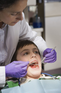 Female dentist examining patient. Date : 2008