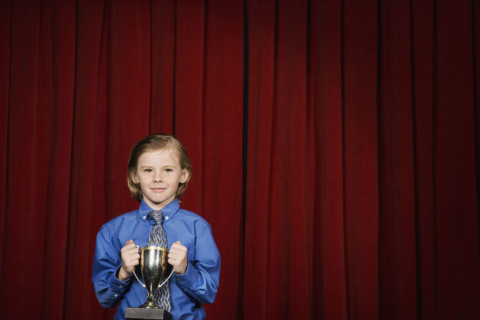 Boy holding trophy on stage. Date : 2008