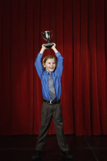 Boy holding trophy on stage. Date : 2008