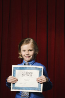 Boy holding certificate on stage. Date : 2008