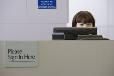 Receptionist sitting behind counter. Date : 2008