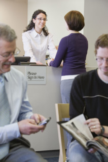 Receptionist talking to woman at counter. Date : 2008