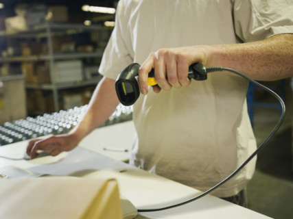 Warehouse worker scanning package. Date : 2008