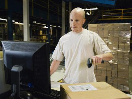 Warehouse worker scanning package. Date : 2008