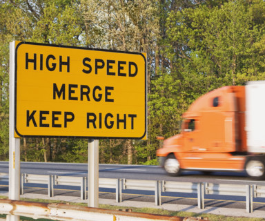 Blurred motion shot of truck driving past street sign. Date : 2008