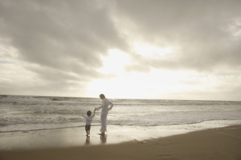 Mother and child holding hands at beach. Date : 2008