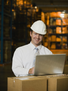 Businessman wearing hard hat in warehouse. Date : 2008
