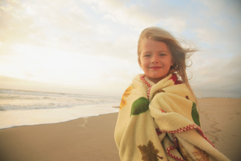 Girl wrapped in blanket at beach. Date : 2008