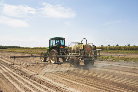 Tractor spraying field, Florida, United States. Date : 2008