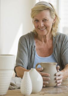 Senior woman making ceramic pots.