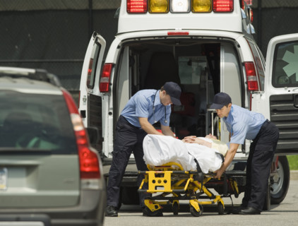 EMTs loading patient into ambulance.