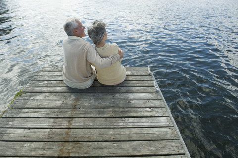 Senior couple hugging on dock.