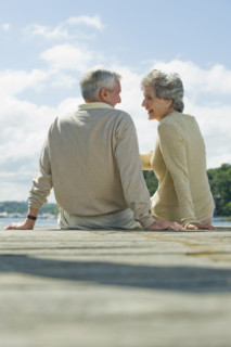 Senior couple sitting on dock.