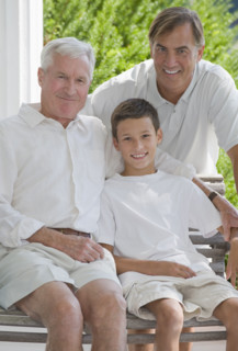 Three generations of men posing on porch.