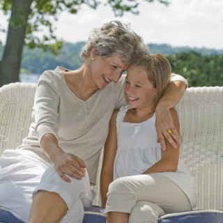 Grandmother and granddaughter sitting on porch.
