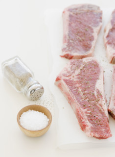 Close up of raw steaks and seasoning. Date : 2008