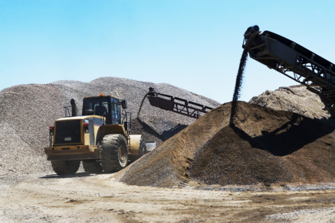 Bucket loader moving pile of gravel. Date : 2008