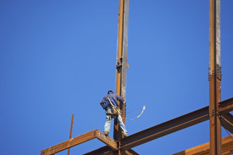 Low angle view of construction worker on beam. Date : 2008