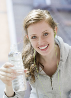 Young woman drinking water after workout. Date : 2008