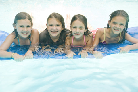 Girls resting on inflatable raft in swimming pool. Date : 2008