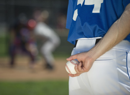 Baseball pitcher preparing to pitch ball.