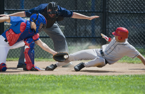 Baseball player sliding into home plate.