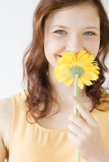 Teenage girl smelling flower. Date : 2008
