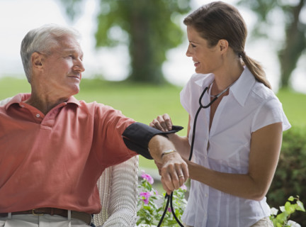Nurse checking senior man’s blood pressure.
