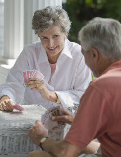 Senior couple playing card game on porch.