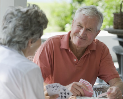 Senior couple playing card game on porch.
