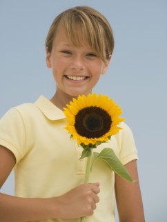 Girl holding sunflower.