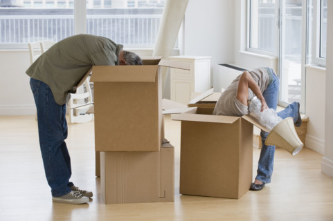 Couple unpacking moving boxes.