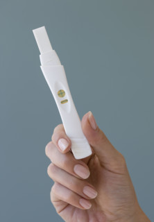 Close up of woman holding pregnancy test.