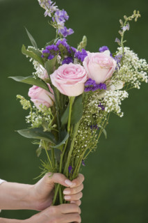 Woman holding bouquet of flowers.