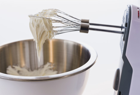 Close up of whipped cream in mixer beaters.
