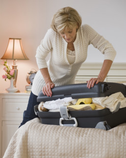 Woman packing full suitcase.