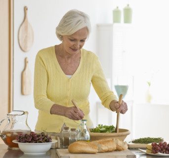 Senior woman tossing salad.