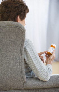 Senior woman reading prescription label.