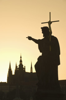Silhouetted statue and cathedral.